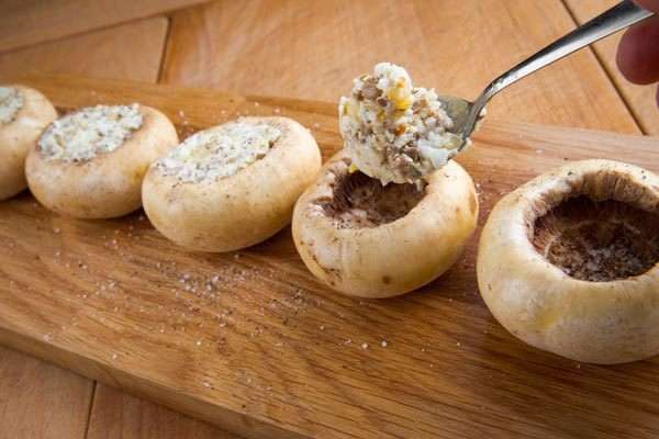 Шляпки грибов посолить и поперчить по вкусу, смазать оливковым маслом и наполнить приготовленной начинкой. Форму для запекания смазать маслом, выложить грибы, положить в каждую шляпку кусочек сливочного масла. Шляпки грибов посолить и поперчить по вкусу, смазать оливковым маслом и наполнить приготовленной начинкой. Форму для запекания смазать маслом, выложить грибы, положить в каждую шляпку кусочек сливочного масла.