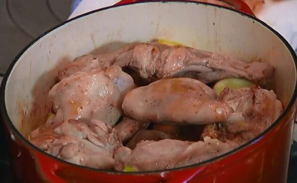 Вернуть кусочки кролика в кастрюлю с яблоками и луком, полить все соком, который выделился, пока мясо отдыхало.