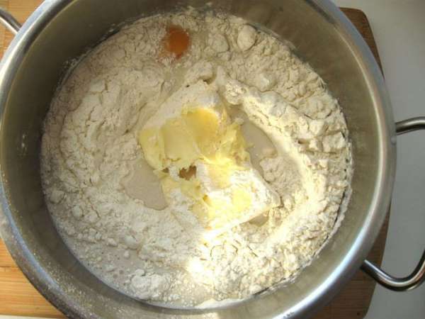 Добавить к смеси 1 яйцо, 100 г сливочного масла и муку.