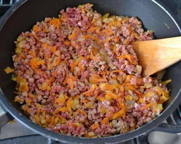 Добавить к овощам фарш и, помешивая пару минут, дать смеси прогреться.