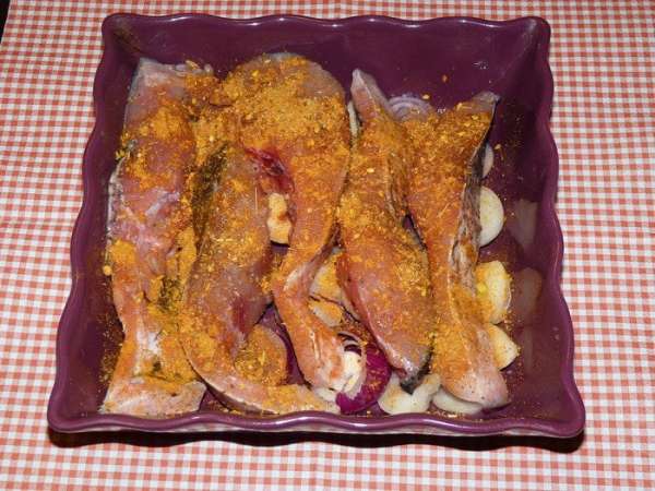 Рыбу уложить на лук. Добавить специи.