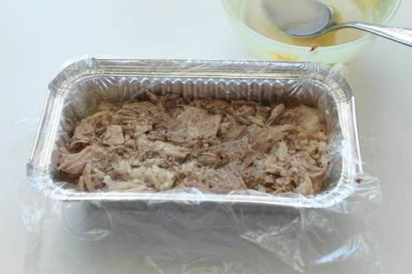 На кожу в форму уложить половину подготовленного мяса. Утрамбовать. Залить мясо несколькими ложками желатинового бульона. 
