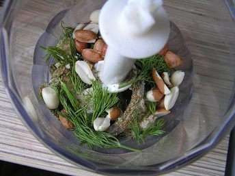 Зелень помыть, обсушить. У мяты и кориандра оборвать листики, сложить в чашу блендера, добавить лук, арахис, хлеб, пряности.