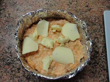 Формочки смазать маслом, посыпать сухарями, выложить морковную массу, а сверху кусочки сливочного масла.
