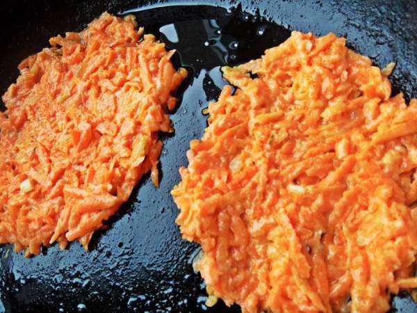 На сковороду наливаем масло, кладём ложку морковной смеси, расплющиваем ложкой.