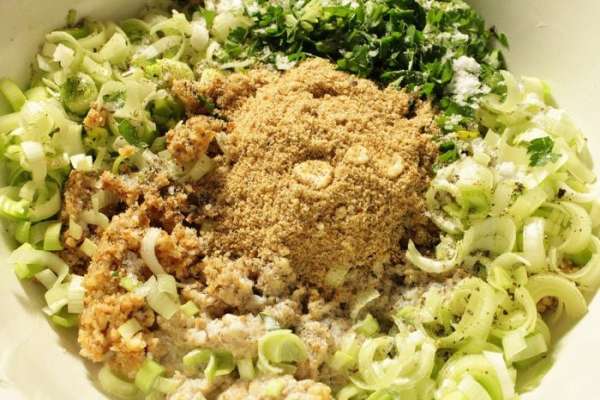 Добавить нарезанный полукольцами лук порей, зелень, сливки, 2 столовые ложки сухарей, посолить и поперчить по вкусу, перемешать