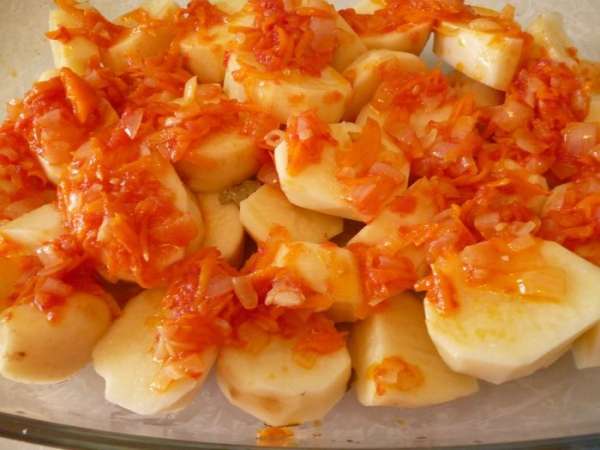 Картофель почистить и нарезать поперек или дольками. Выкладываем слой картофеля в форму для запекания (я запекаю в стеклянной), покрываем половиной овощной заправки.