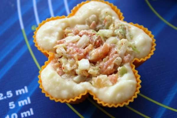 В формочки для кексов, смазанные маслом, выложить (по 1 ст.л. с горкой) картофельное пюре и распределить его по краям, как корзиночки. В центр вложить начинку, немного придавив ложкой