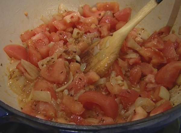 Добавить морковь, помидоры и рис, влить пол-литра кипящей воды и посолить. Довести до кипения, накрыть крышкой, убавить огонь и варить на медленном огне 12—15 минут.