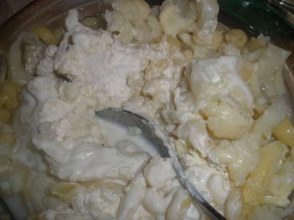 Выливаем стакан слитой воды, добавляем сыр, сметану и 2 столовые ложки муки, солим. Приправляем розмарином и присыпаем сухарями. 