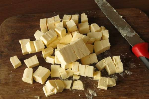 Нарезаем масло кубиками, если продукт подтаял, кладем его в морозильник, пока подготовим фарш.