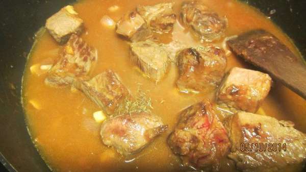Добавляем воду так, чтобы она полностью покрыла мясо. Солим, перчим по вкусу, кладем веточку тимьяна (или хорошую щепотку сушеного). Накрываем крышкой и готовим на среднем огне 1 ч 15 минут, периодически помешивая. 
