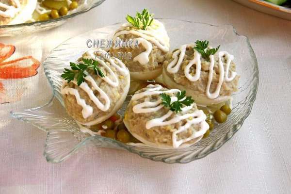 При подаче картофель, морковь, огурец нарезаем кружочками и раскладываем на блюдо. Укладываем сверху фаршированные яйца. Красиво поливаем майонезом. Украшаем зелёным горошком и посыпаем оставшимися желтками.