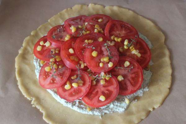 Разложить колечки помидоров внахлест, посыпать оставшейся кукурузой, сверху выложить веточки тимьяна.