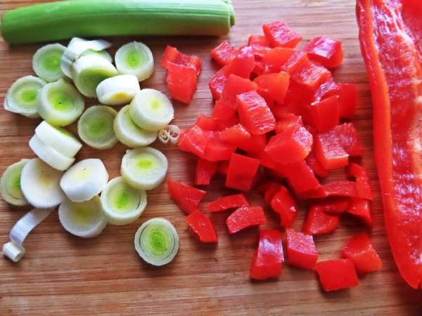 Порей нарезать колечками, перец — кубиками.