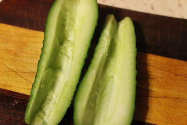 Морепродукты сложить в дуршлаг и дать маслу стечь. Яйца, крабовые палочки и огурец нарезать кубиками, предварительно удалив у огурца семечки.