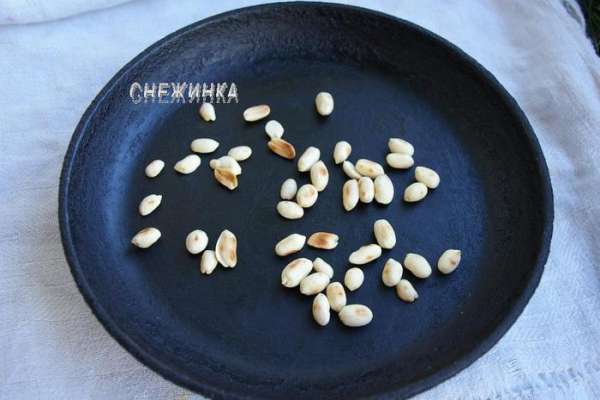Для украшения нам понадобится жареный арахис. Можно купить готовый, у меня был бланшированный, но не жареный. Поэтому отправляем его на хорошо разогретую сухую чистую сковороду и держим на небольшом огне, помешивая, чтобы орехи не подгорели. Когда они немного зазолотятся с двух сторон, выключаем огонь и даём арахису полностью остыть.