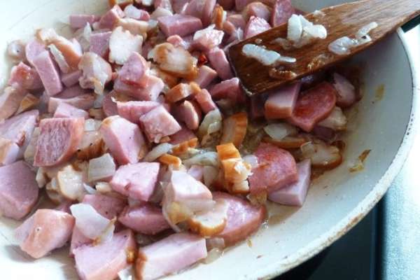 На сковороде припустим нарезанный  лук и чеснок до прозрачности, добавим мясопродукты и обжарим до золотистого цвета.