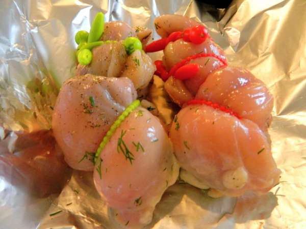 Кладем в каждую половинку сливочное масло, нарезанное кусочками, закрываем «карман» с начинкой  и перевязываем.