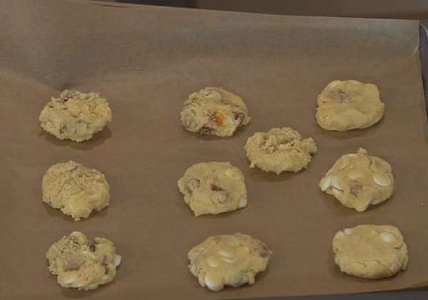 Из теста сформировать небольшие лепешки и выложить на противень на некотором расстоянии друг от друга.