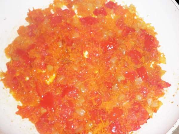 Затем снять кожицу с помидорок, порезать кубиками и добавить к обжарке. Посолить, поперчить и протушить до размягчения помидор.