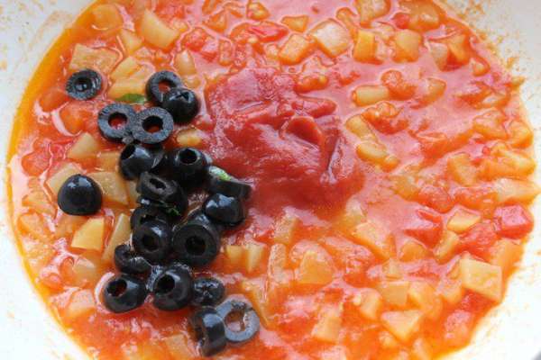 Добавить соль, перец и сахар по вкусу. Затем добавить томат-пасту и порезанные колечками оливки, тушить еще 5 минут.