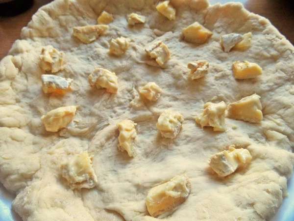 Растянуть в пласт и положить для начинки сыр кусочками. 
