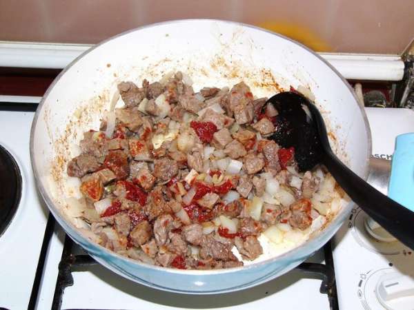 Овощи очищаем и нарезаем кубиками. У меня нет единого мнения, на каком этапе лучше добавить лук. В этот раз я добавила его к обжаренному мясу, жарила еще пару минут, потом добавила томатную пасту. Ее тоже полагается слегка обжарить.