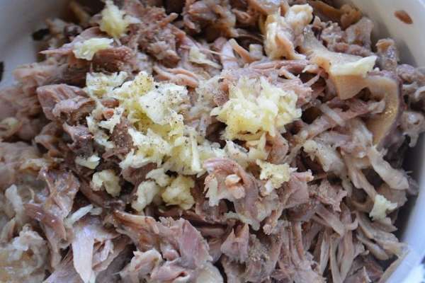Мясо разобрать на волокна и добавить чеснок через пресс и свежемолотый черный перец, перемешать. Мясо разобрать на волокна и добавить чеснок через пресс и свежемолотый черный перец, перемешать.