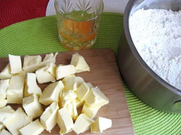  Приготовить тесто:  масло порезать кубиками и охладить (в холодильнике, а не в морозильной камере).