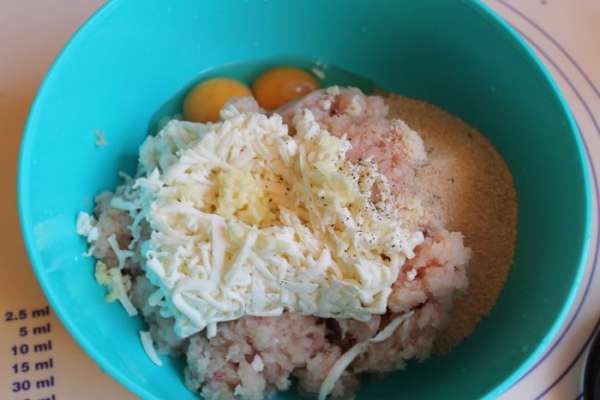 Теперь смешаем фарш с яйцами, сыром. Добавим молотые сухари, соль по вкусу, так же зелень рубленую, чеснок выдавленный. Помидоры у меня были сухие. Я их заранее замочила, и затем порезала и добавила также в фарш. 