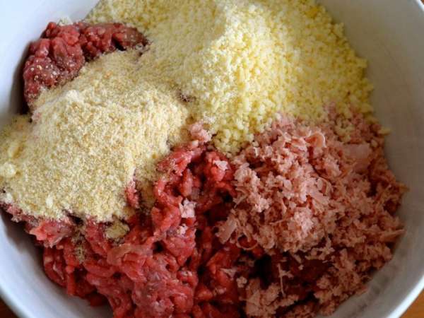 В глубокой миске смешать мясной фарш, измельченную колбасу, мелко тертый сыр и панировочные сухари.