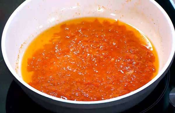 Перец чили мелко порезать, добавить в сковороду с чесноком и слегка обжарить, затем добавить помидоры и на среднем огне уварить соус.