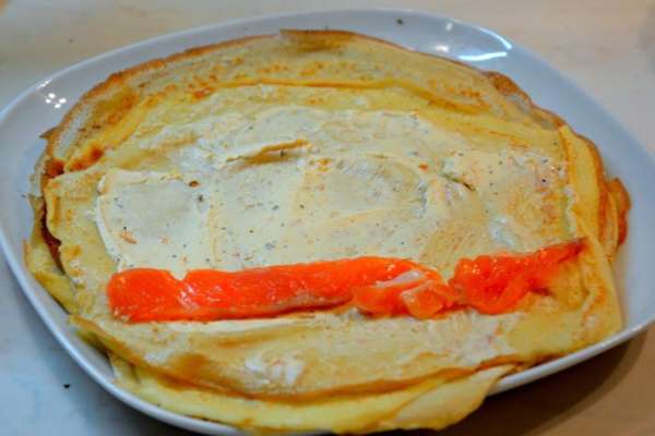 Нарезать рыбу соломкой. Намазать блин сливочным сыром, выложить кусочек рыбы, свернуть.
