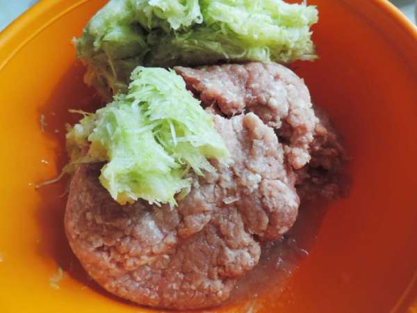 Лук пропускаем через мясорубку (или измельчаем в бледере), молодой кабачок натираем на мелкой терке (как на драники), добавляем готовый фарш, перемешиваем.