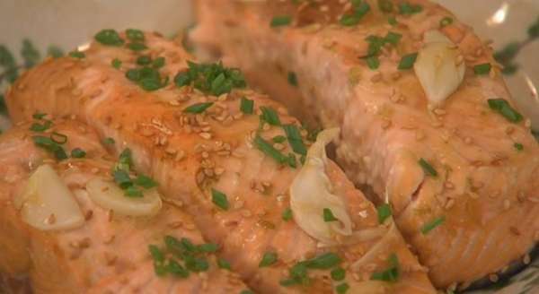Готовую рыбу посыпать кунжутным семенем и луком.