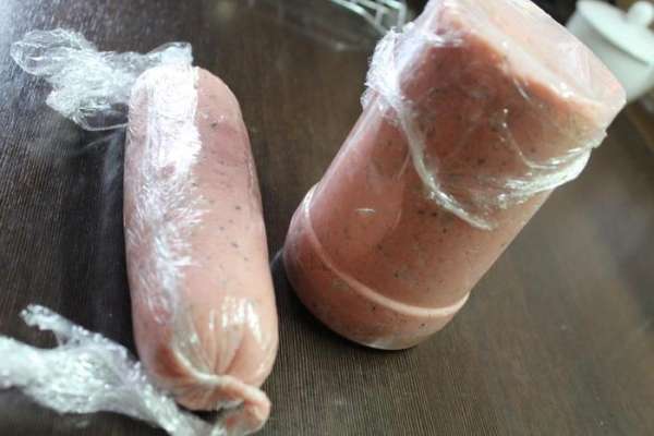 И выкладываем в формы. Это может быть большой пластиковый стакан, бутылка со срезанным горлом, либо подходящая силиконовая форма.
А можно просто остывшую массу завернуть в пищевую пленку и руками придать форму колбасы. Накрываем верх пленкой и ставим в холод до полного застывания. Время будет зависеть от размера.  Я как-то делала тонкие колбаски, типа сосисок, и им хватило пары часов. Таким формам, как на фото, понадобилось часа 4.
