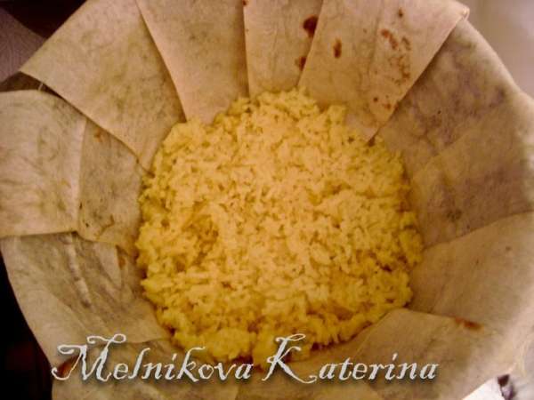 Затем выложить слой мяса. Чередуя, выложить весь рис и мясо. 