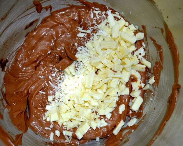 Белый шоколад нарезать не очень мелкими кусочками и добавить в крем. Перемешать. Белый шоколад нарезать не очень мелкими кусочками и добавить в крем. Перемешать.