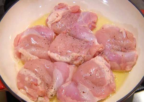 Разогреть в тяжелой сковороде оливковое масло и обжаривать кусочки курицы с двух сторон до появления золотистой корочки.