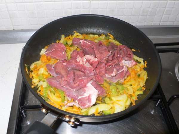 Добавляем мясо, порезанное небольшими кусочками, солим перчим. Выливаем вино. 
Когда испарится алкоголь, а для этого нужно пару минут, накрываем крышкой, убавляем огонь до минимального и тушим мясо с овощами 2 часа. Оригинальный рецепт предполагает 5 часов, но это слишком ))), все же, мы не в Средневековье.  