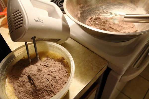 Взять половину просеяной сухой смеси, всыпать в мясляно-сахарно-яичную смесь и хорошо размешать.