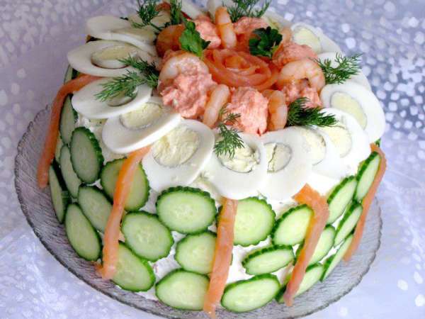 Для украшения аккуратно нарезать яйца и огурцы кружками. Огурцы порезать очень тонко. Украсить торт креветками, ломтиками семги, яйцами, икрой по собственному вкусу. Бока торта обложить кружками огурцов. Наш торт готов. Приятного аппетита!
