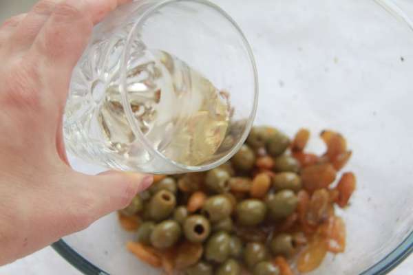 Через указанное время вынуть курицу и выложить мясо в форму для запекания (у меня керамическая овальная объёмом 2,5 литра). В маринад добавить белое вино, перемешать.