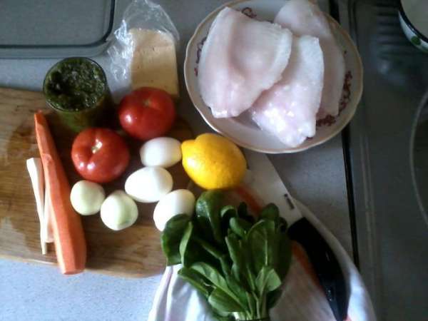 Подготовить продукты: разморозить филе рыбы, приготовить соус песто, очистить картофель, морковь, корень петрушки, лук, отварить и почистить яйца, вымыть и высушить шпинат.