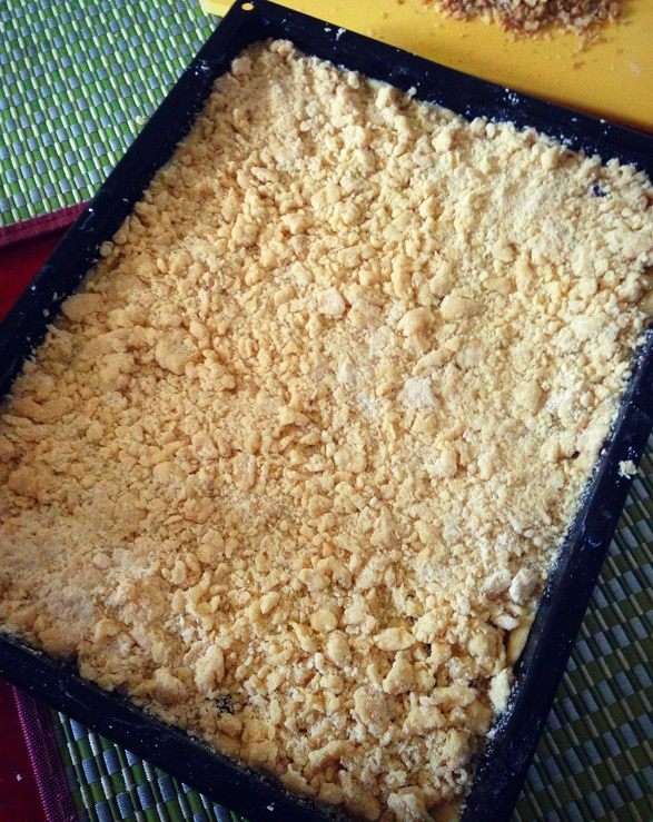 Посыпаем наш пирог равномерно по всей поверхности крошкой и орешками. 