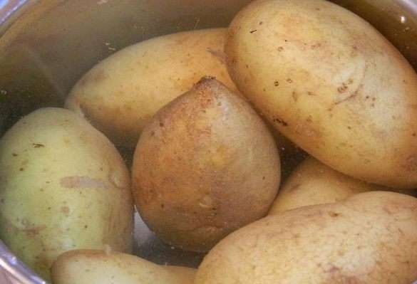 Картофель хорошо помыть с щеточкой. Сложить в кастрюлю, залить водой и отварить до готовности. Остудить и разрезать на две части вдоль.