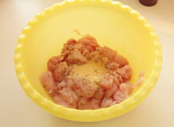 С курицы срезать мясо и порезать его средними кубиками приблизительно 2х2 см. Посыпать мясо солью, перцем и орегано. Добавить  желатин. Хорошо перемешать.