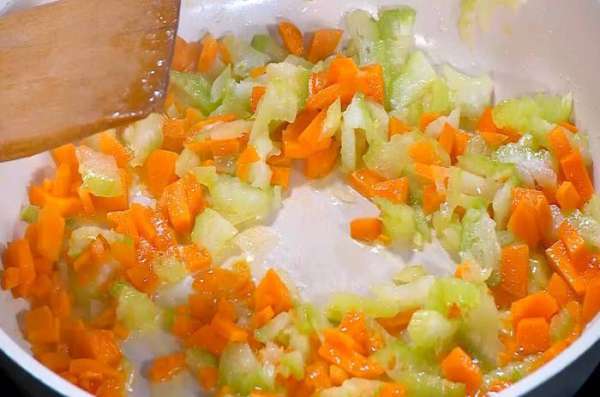 Морковь почистить, нарезать маленькими кусочками и добавить в сковороду.