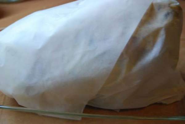 Завернем курицу в промасленную бумагу и поставим запекаться в предварительно разогретую до 180 градусов духовку.